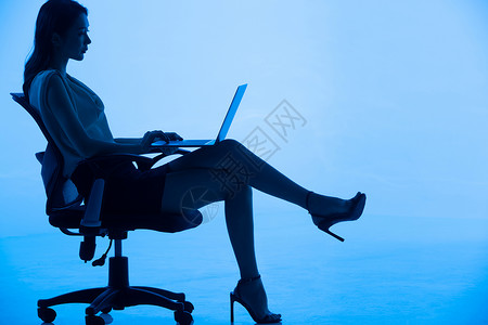 成功人士剪影青年女士坐在椅子上使用平板电脑背景