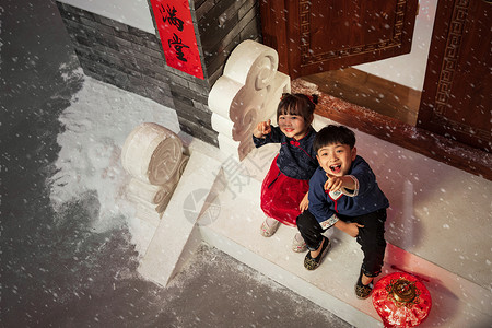 向上伸手坐在门口台阶上看雪花的男孩女孩背景