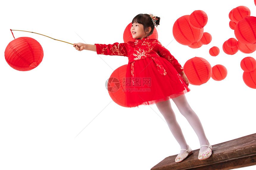 红灯笼旁提着灯笼玩耍的小女孩图片