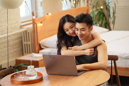 冲浪的情侣青年夫妇在家使用电脑背景