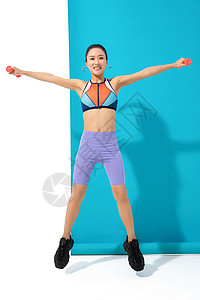 年轻女人举哑铃锻炼身体图片