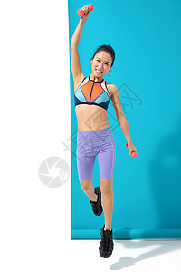 年轻女人举哑铃锻炼身体图片