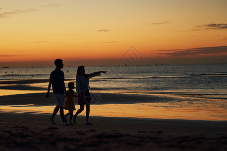 母亲和孩子剪影一家三口在海边度假背景