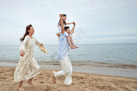 跳起来的女孩一家三口在海边玩耍背景
