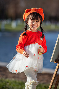 顽皮的小女孩可爱的小女孩在户外画画背景