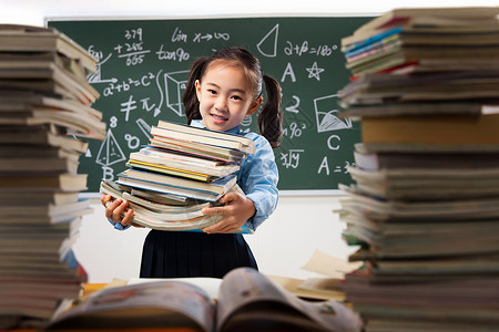 搬书搬着沉重课本的小学女生背景