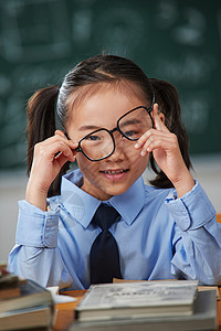 戴眼镜的小学女生户内高清图片素材