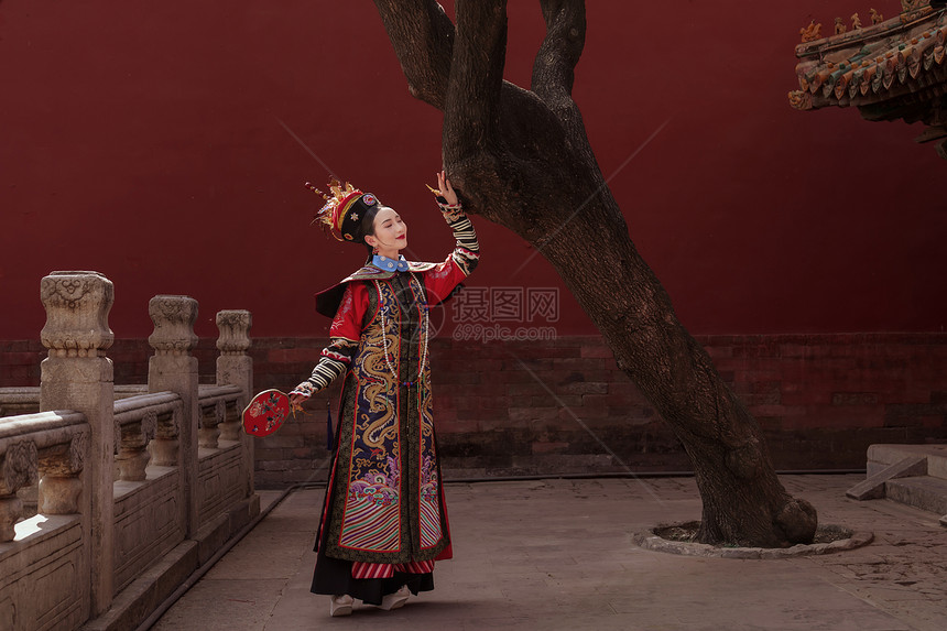 穿清宫服的青年女人站在古树下图片