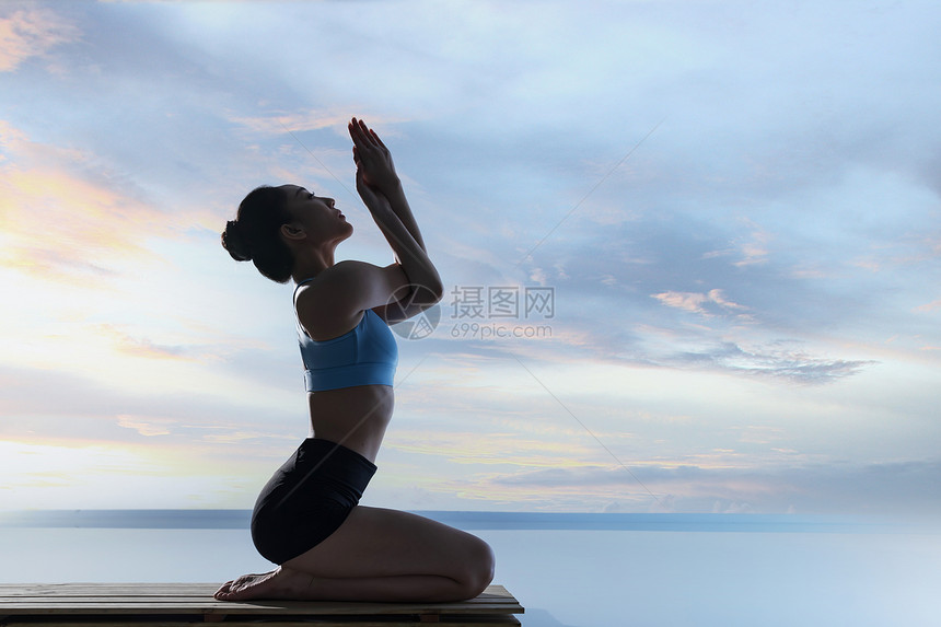 年轻女人在水面上练习瑜伽图片