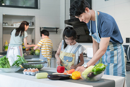 年轻父母教孩子学做饭乐趣高清图片素材