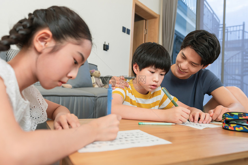 年轻爸爸辅导孩子做作业图片