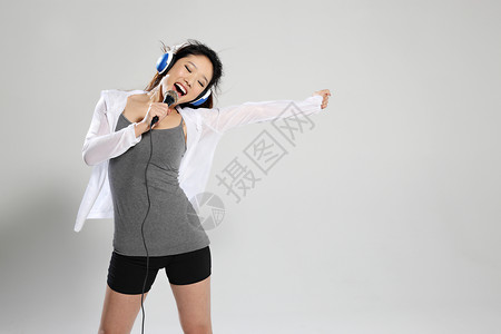 一个年轻女人听音乐唱歌高清图片