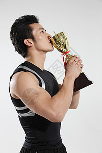 东方男青年运动员亲吻奖杯图片