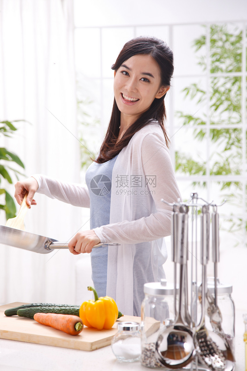 年轻女人在厨房做饭图片