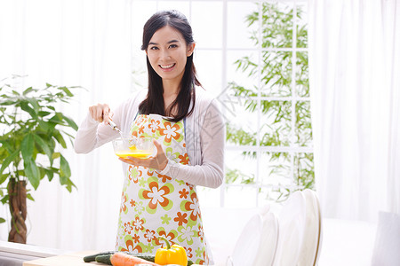 在碗里鸡蛋年轻女人在厨房做饭背景