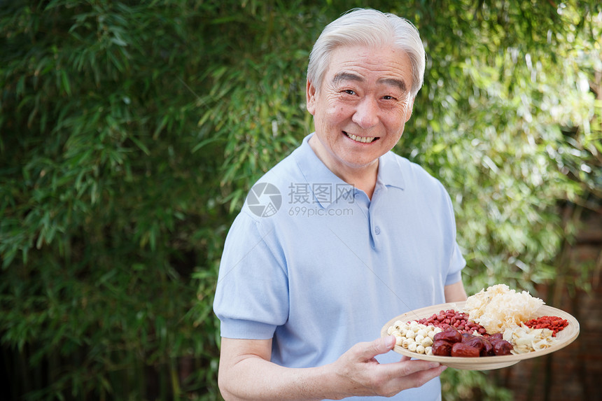 一个老年男人拿着干果图片
