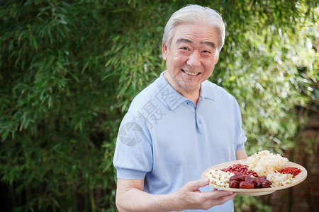 百合莲子银耳羹一个老年男人拿着干果背景