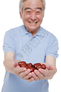 一个老年男人捧着红枣图片