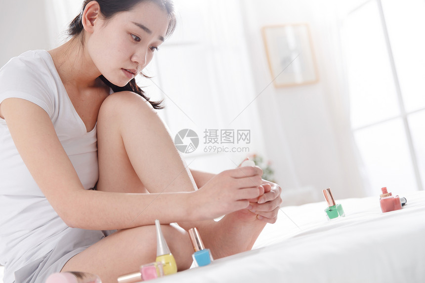 青年女人在涂指甲油图片