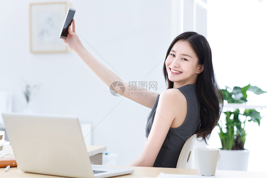 商务女人使用手机自拍图片