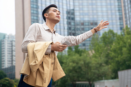 商务男士在商业区拦出租车高清图片