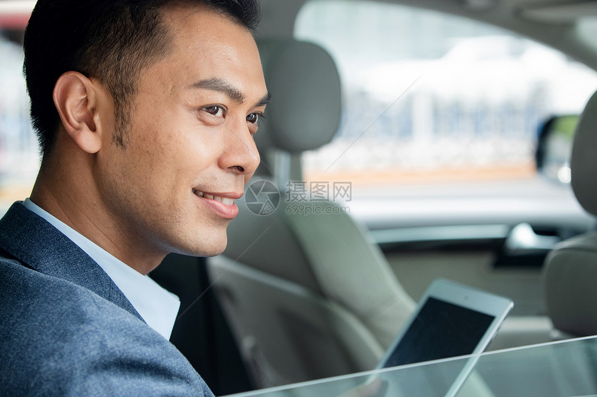 坐在汽车里拿着平板电脑的商务男子图片