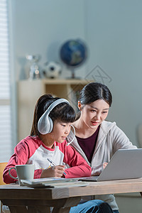 年轻妈妈辅导女儿上网课高清图片