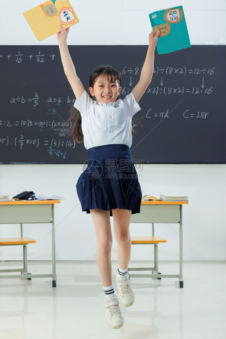 快乐的小学女生在教室里欢呼跳跃图片