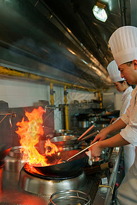 后厨内的专业厨师团队烹饪美味佳肴厨师帽高清图片素材