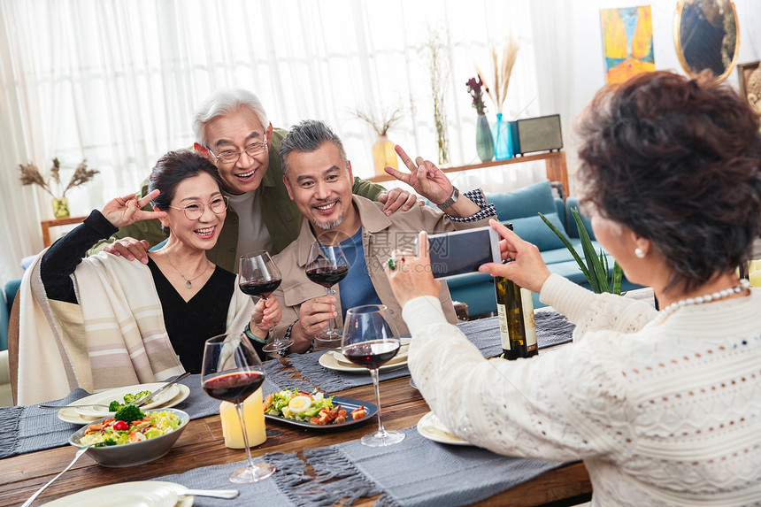 聚餐时中老年人用手机拍照图片