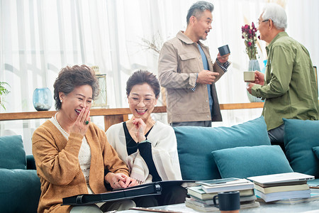 退休的中老年人在居室喝茶聊天看相册叙旧夫妇高清图片素材