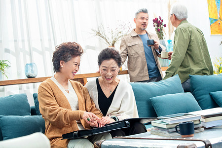 快乐的中老年人们在居室喝茶聊天看相册女人高清图片素材