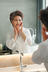 浴室照镜子老年人做面部护理背景