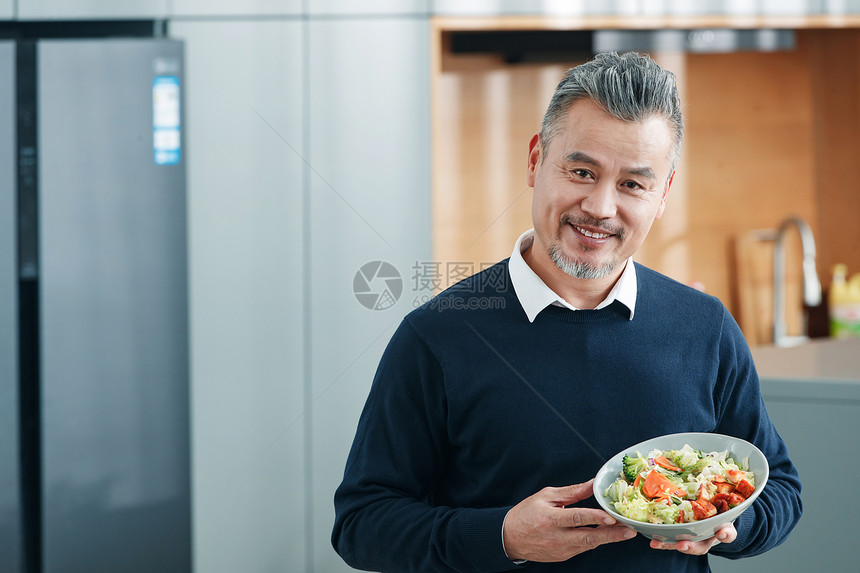 拿着蔬菜沙拉的中老年男士图片