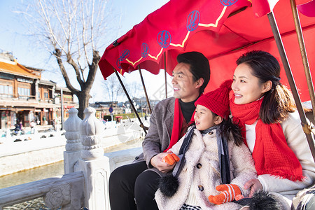 冬天的小孩一家三口坐人力黄包车旅游背景