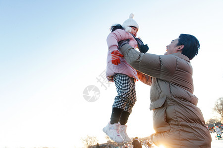 抱着太阳的女孩父亲和女儿在滑冰场玩耍背景