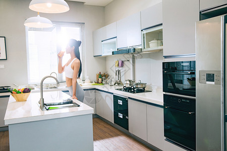 穿着运动装的青年女人在厨房背景图片