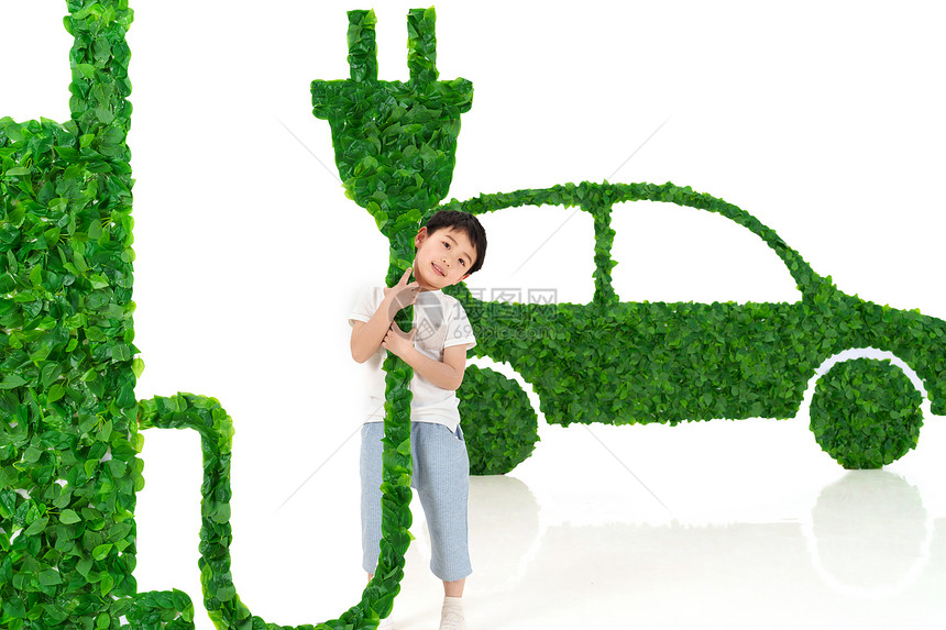 快乐的小男孩给新能源汽车充电图片
