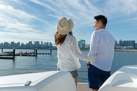 海景情侣浪漫的青年夫妇站在游艇甲板上背景