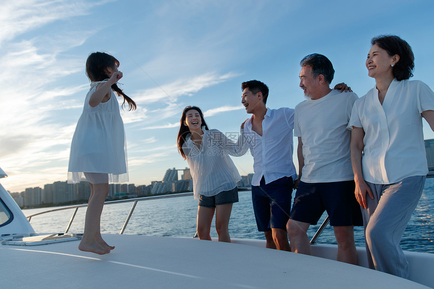 夕阳下在游艇上的快乐一家人图片