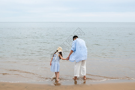 父女海边度假快乐父女在海边玩耍背景