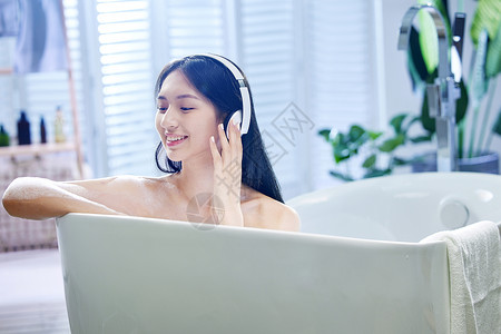 浴室性感美女浴缸内听音乐的年轻女孩背景