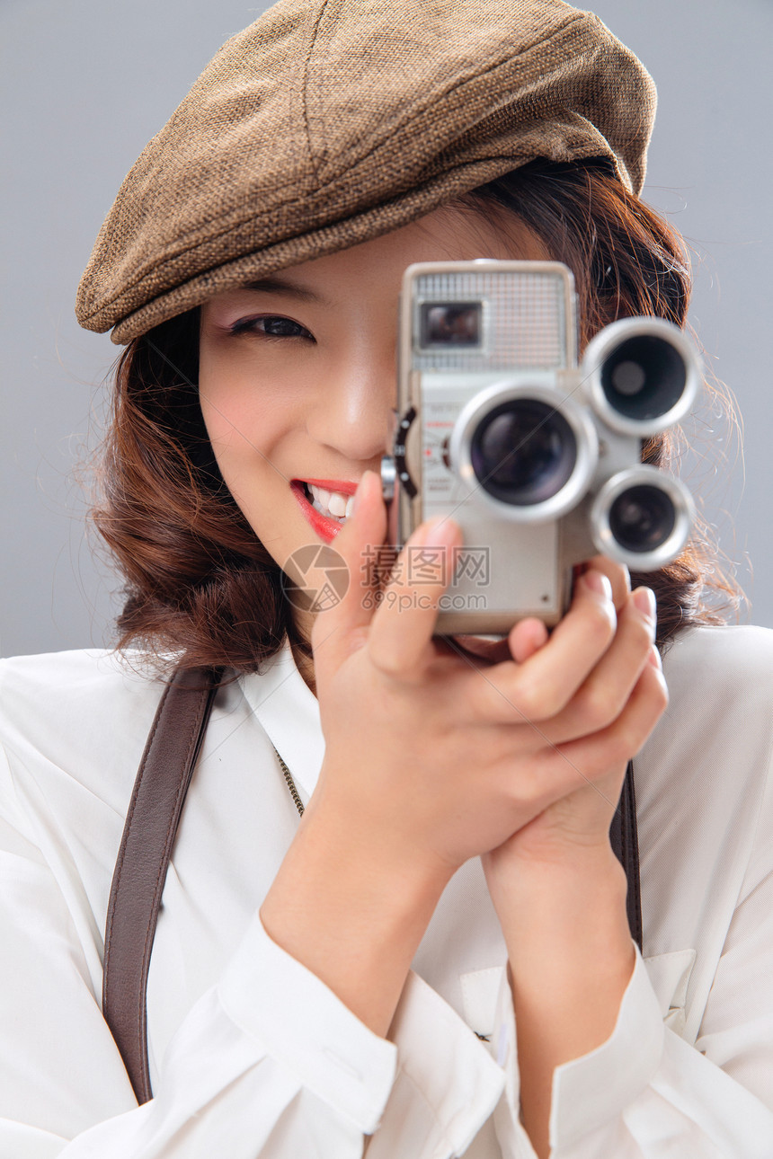 年轻女孩拿着古典式照相机图片