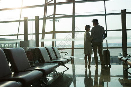 逆光窗户青年情侣在机场候机厅背景
