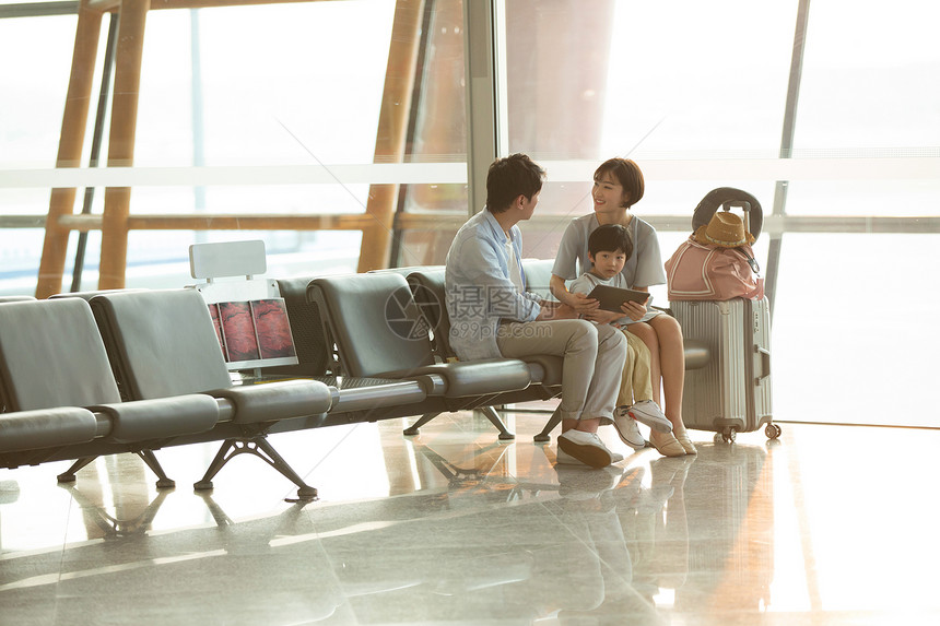 一家三口坐在机场候机大厅图片