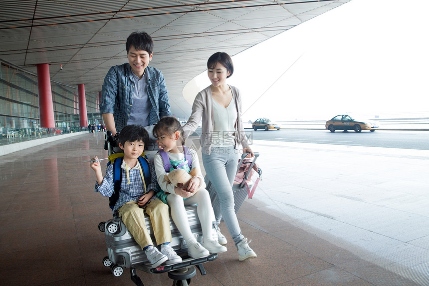 欢乐家庭在机场推着行李图片