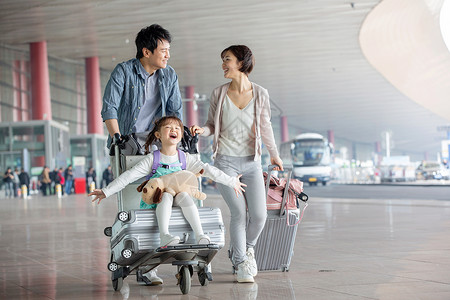 快乐家庭在机场推着行李高清图片