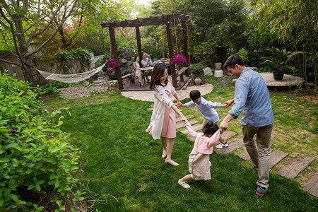 走石板路女孩快乐家庭在庭院里玩耍背景