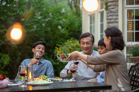 快乐大家庭在庭院里用餐高清图片