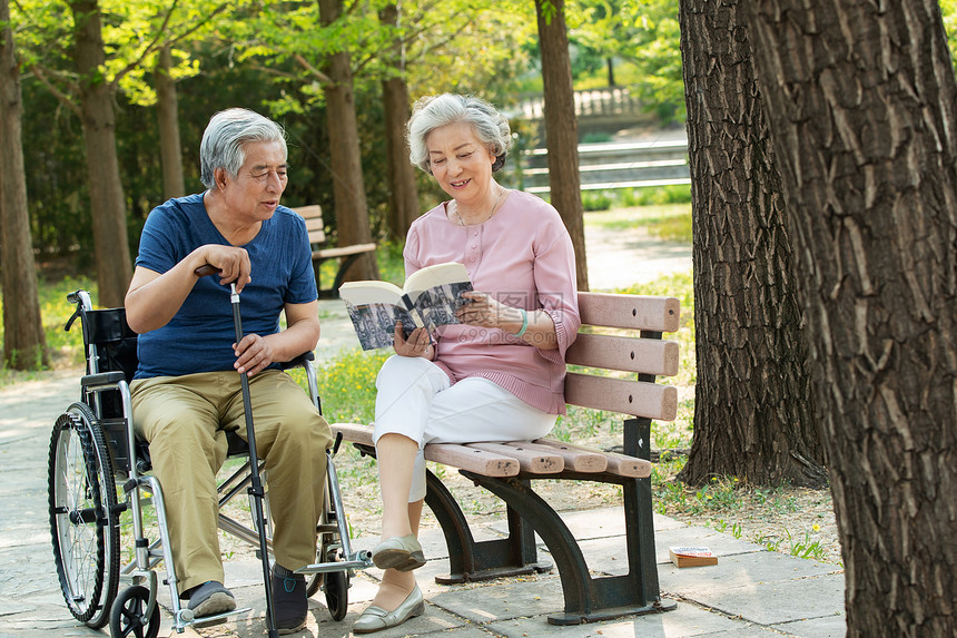 老年夫妇坐在公园里看书图片